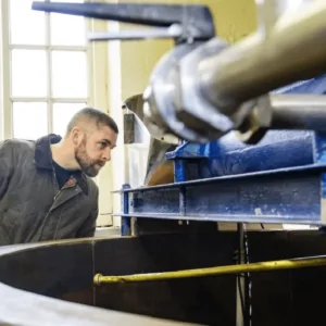 Batemans Brewery Tours - a man looking at the brewing equipment