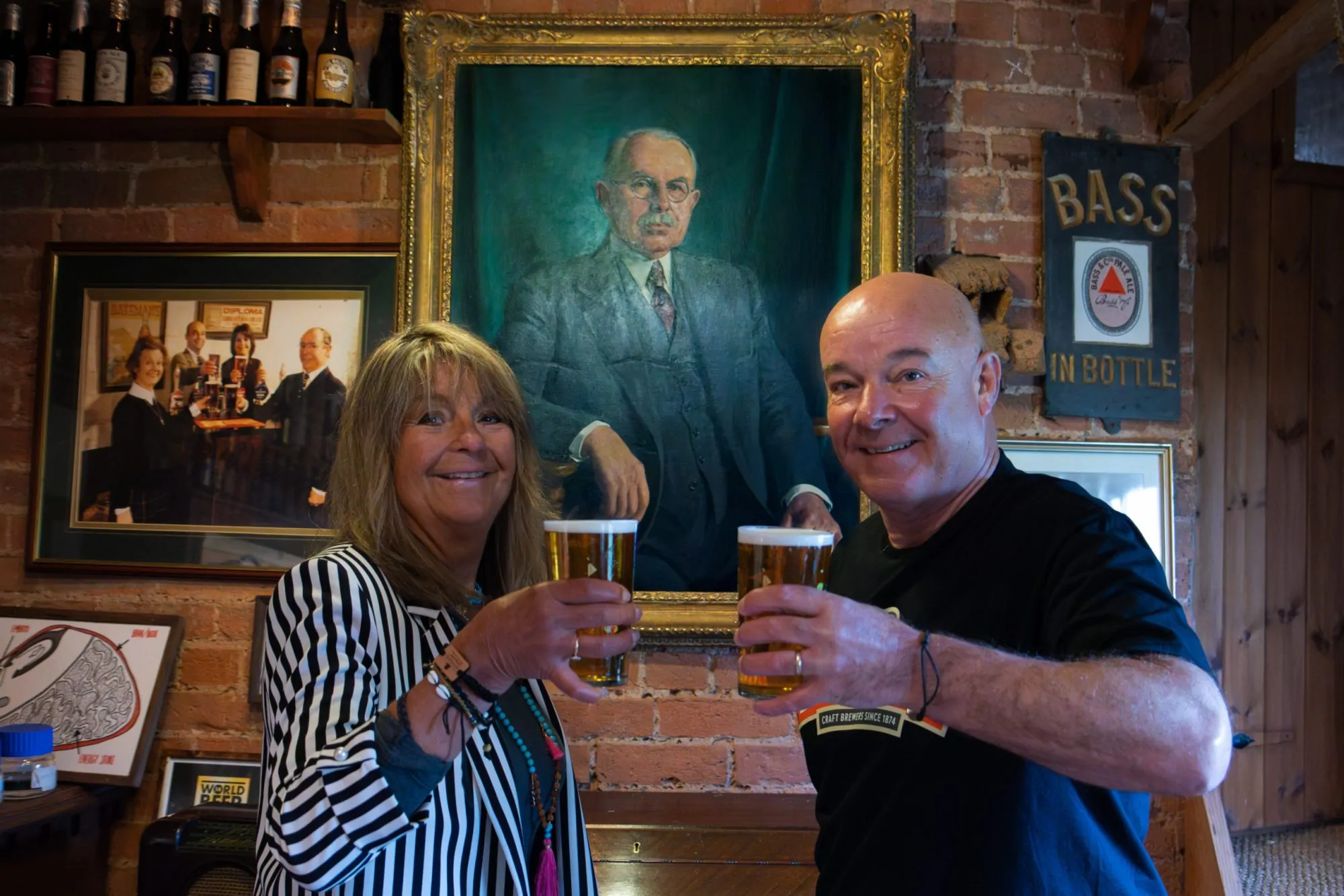 Batemans Family Story, Jacqui and Stuart Bateman in front of a picture of their ancestor