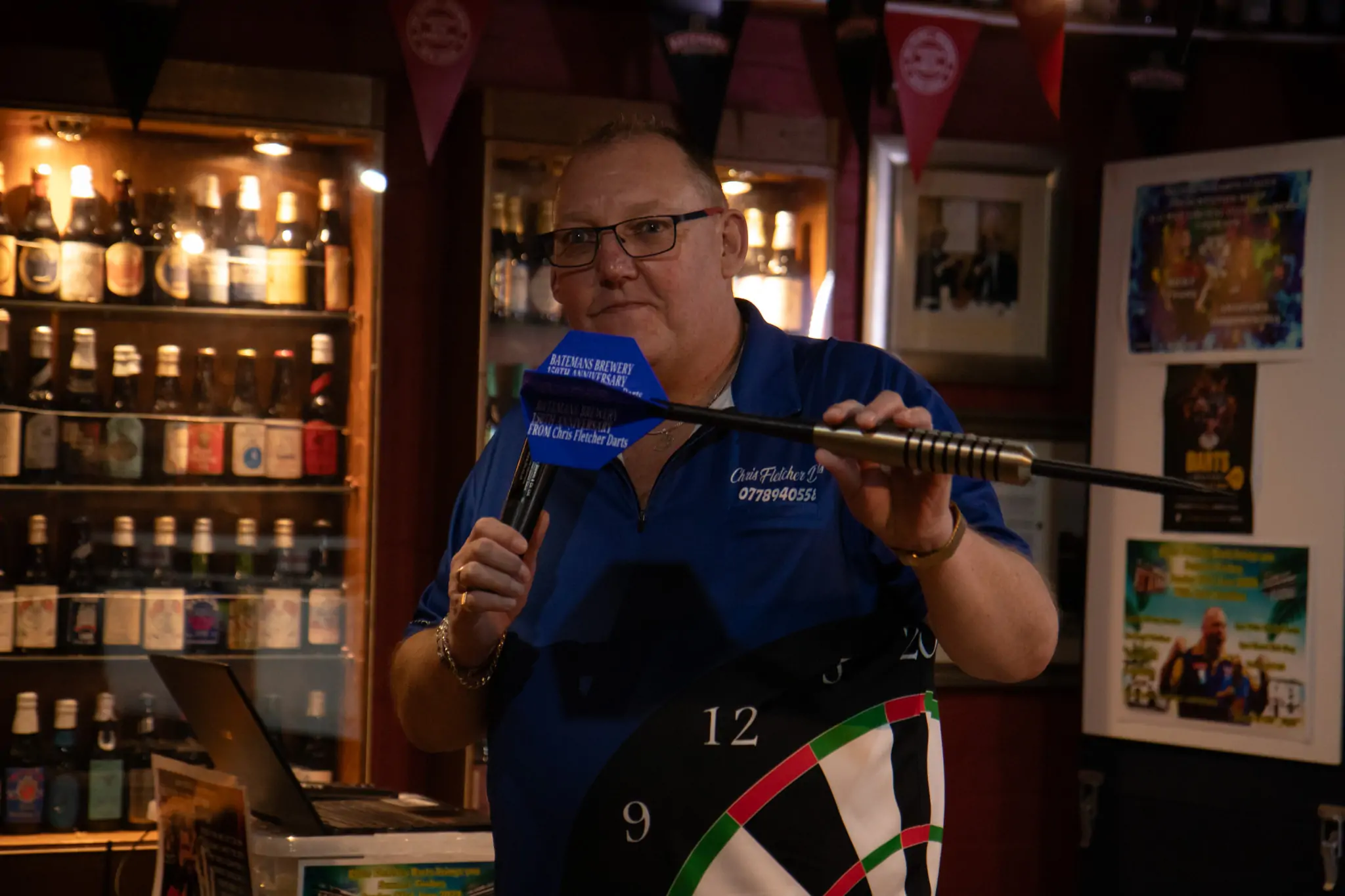 Peter Manley Pro Darts Player at the Batemans 150th anniversary celebrations darts - Chris Fletcher presenting a Large Dart memento to the Batemans Family.